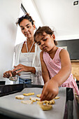 Mother and daughter baking biscuits