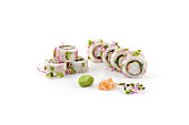 Elegant sushi rolls garnished with sprouts and wasabi