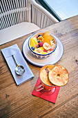 Healthy fruit salad and a drink on a wooden table