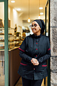 Pastry chef in the bakery with vegan donuts on display