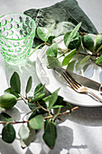 Elegant table setting with feijoas and green glassware