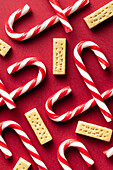 Top view of Christmas candy canes and butter cookies on red