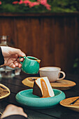 Hand pouring pouring caramel sauce on a cheesecake into a cheesecake