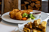 Traditional schnitzel with chips and vegetables in a cosy setting