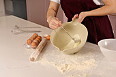Person mixes ingredients in a bowl for baking
