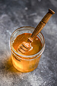 Organic honey in a jar with a wooden spoon, seen from above