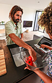 Friends prepare food together in a stylish kitchen