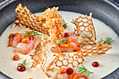 Gourmet prawn dish with crispy delicacies and cream sauce