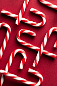 Red and white candy canes from above on a red background