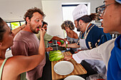Freunde lachen und kochen zusammen in einer modernen Küche