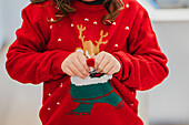 Child in festive Christmas jumper holding decoration