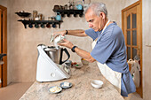 Man preparing dough with a modern kitchen appliance