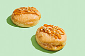 Vegan donuts with carrot cake filling, glaze and nut topping