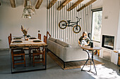 Woman relaxing in living room with rustic dining area