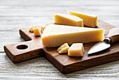 A piece of Parmesan cheese on a wooden board