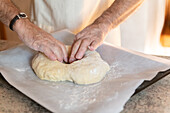 Elderly hands moulding the traditional Epiphany cake dough