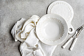 Elegant white tableware on a textured surface