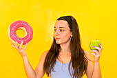 Woman decides between a donut and an apple