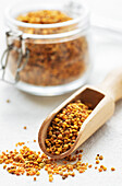 Healthy bee pollen grains. Bee pollen on a wooden spoon and gla