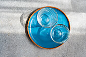 Blue glass bowls on a sandy backdrop