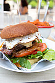 Gourmet burger with fresh lettuce, tomato, and a fried egg