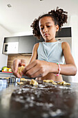 Young girl prepares home-baked biscuits in the kitchen