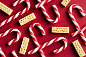 Top view of candy canes and butter biscuits on red background