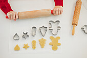 Kind bei der Zubereitung von Weihnachtsplätzchen mit festlichen Ausstechern