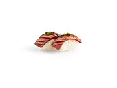 Two pieces of flamed tuna nigiri with tuna topping on a white background