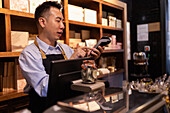 Saleswoman with credit card terminal in a chocolate shop