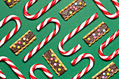 Top view of candy canes and chocolate treats on green backdrop