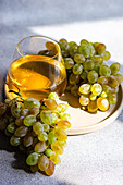 Glass of white wine accompanied by fresh green grapes