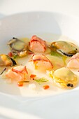 Tasty haute cuisine seafood with sauce in white bowl