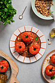 Roasted stuffed tomatoes with brown rice and nuts on ceramic plates