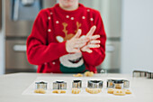 Ein Kind backt Weihnachtsplätzchen in einer festlichen Küche