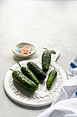 Fresh cucumbers and Himalayan salt on a white plate