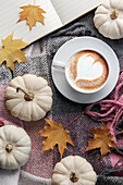 White pumpkins, coffee and autumn leaves