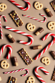 Top view of assorted Christmas candy and cookies on beige background