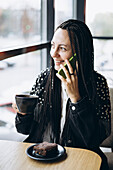 Stylish Caucasian woman enjoying a coffee during a phone call