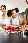 Multi-ethnic family baking biscuits together in a kitchen