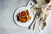 Top view of spicy fried potatoes with tomato sauce