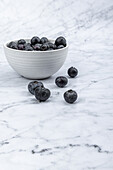 Fresh blueberries in a ceramic bowl on marble