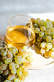 Refreshing white wine and grapes on a sunny background