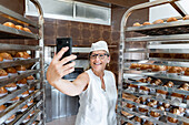 Proud baker takes selfie next to freshly baked pastry