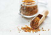 Healthy bee pollen grains. Bee pollen on a wooden spoon and gla