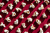 Nostalgic popcorn snack pattern on a red background