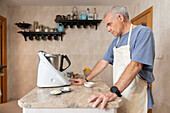 Elderly man prepares Epiphany cake in the kitchen
