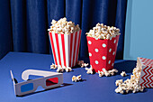 Cinema evening with popcorn and 3D glasses on a blue background