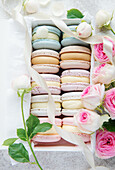 Colourful macaroons in a gift box and roses