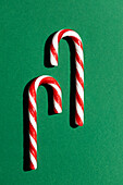 Two candy canes on green background, festive concept